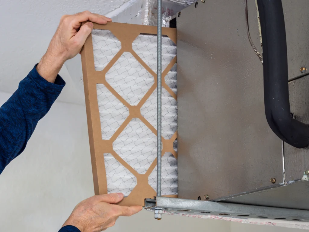 close up of hvac professional inspecting and cleaning ac filter