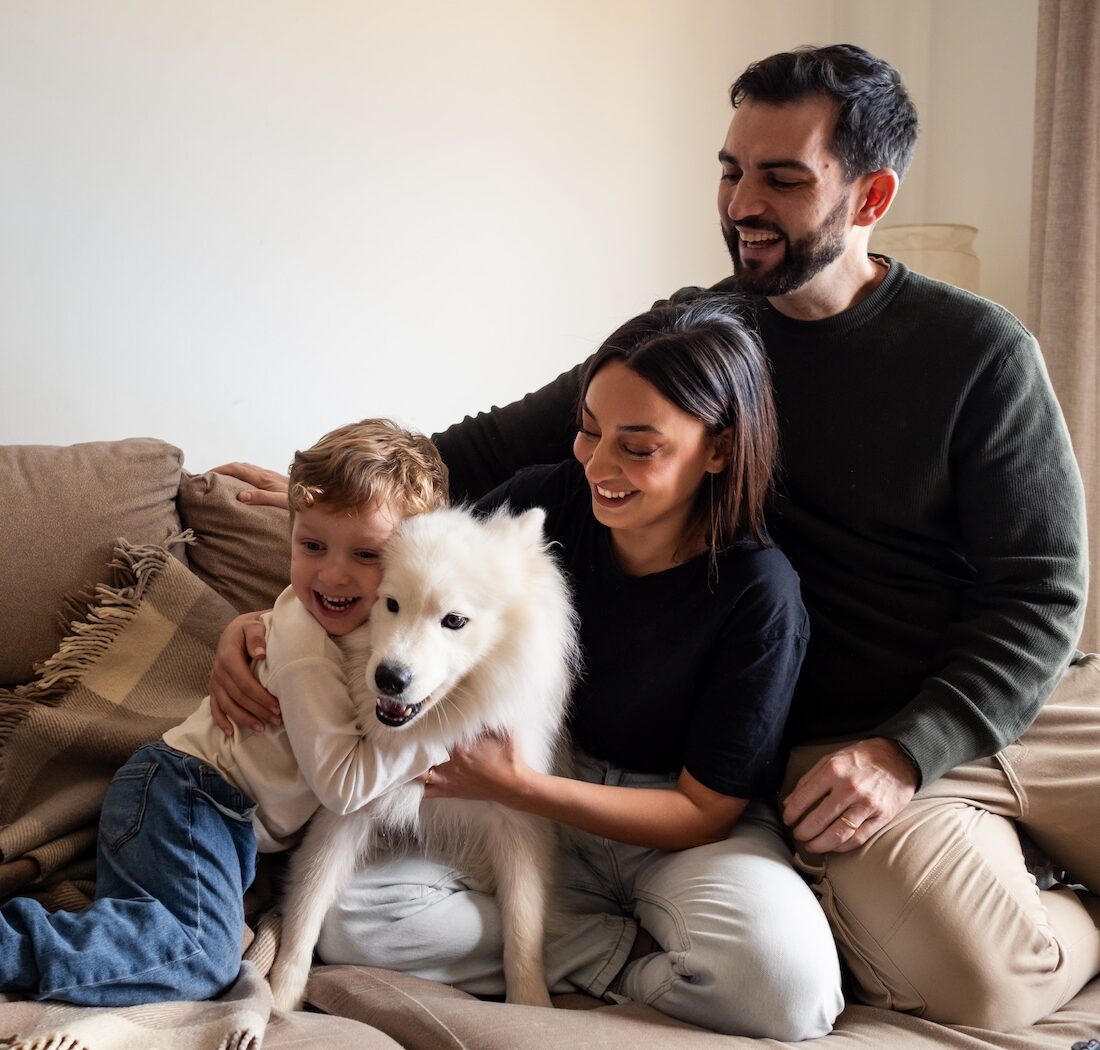 family hugging on couch comfort