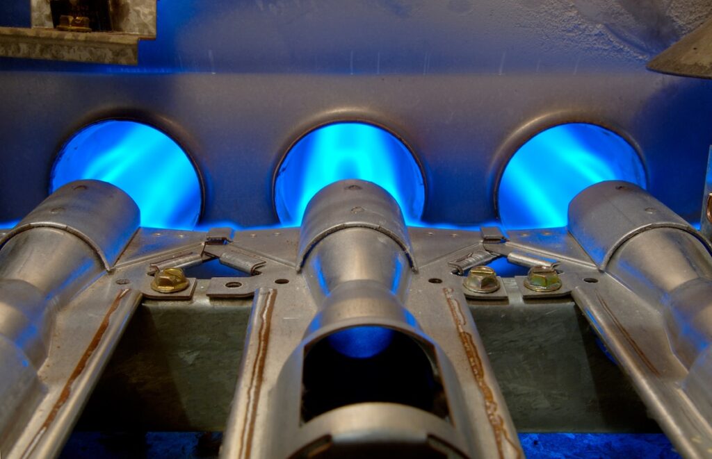 furnace parts Inside a gas furnace. Focus = the top of the middle flange.